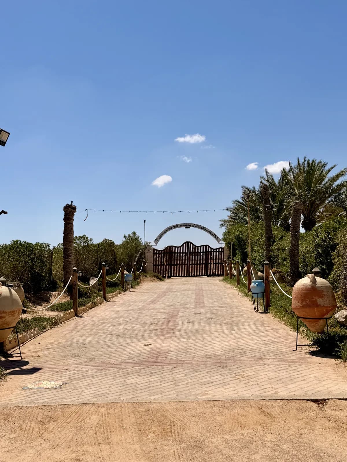 Allée d'entrée du restaurant avec guirlandes et jarres
